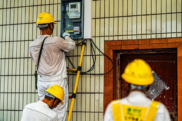 電力員工安裝動(dòng)力電表。國(guó)網(wǎng)永川供電公司供圖