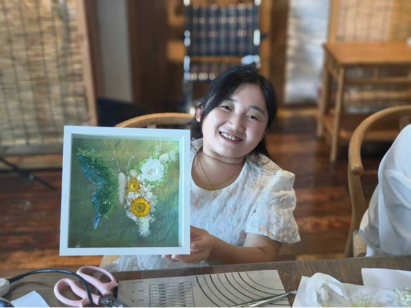 宮燕將培訓中學到的永生花工藝，與毛線鉤針技藝相結合，設計制作出永生花蝴蝶相框。