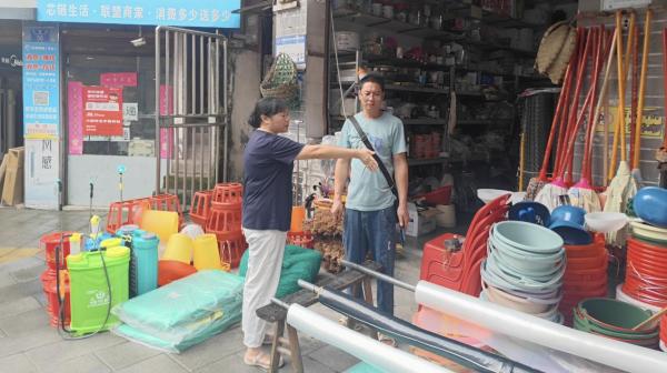 張欽庭規(guī)勸占道經(jīng)營的攤主。東溫泉鎮(zhèn)供圖