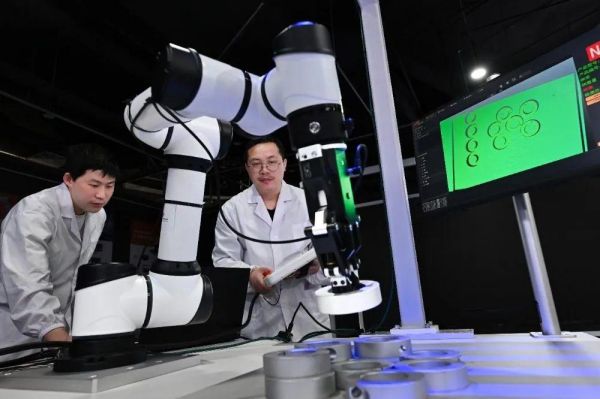 中科搖櫓船研發(fā)人員在對(duì)3D結(jié)構(gòu)光相機(jī)配合機(jī)械臂抓取工件的場(chǎng)景進(jìn)行優(yōu)化調(diào)試。中科搖櫓船供圖