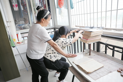 李遇梅攥著女兒僵硬的身體不斷練習(xí)下蹲。楊青攝