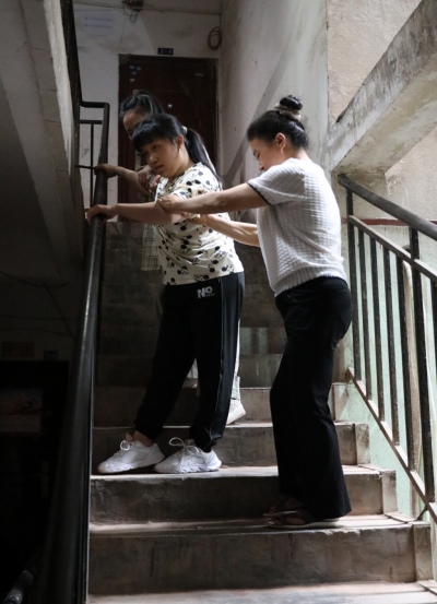 李遇梅正扶著女兒下樓。趙英如攝