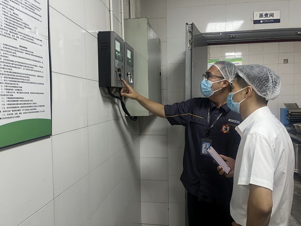 在四川儀表工業(yè)學(xué)校，“紅巖燃小兵”向工作人員講解報(bào)警器注意事項(xiàng)。重慶燃?xì)饧瘓F(tuán)供圖