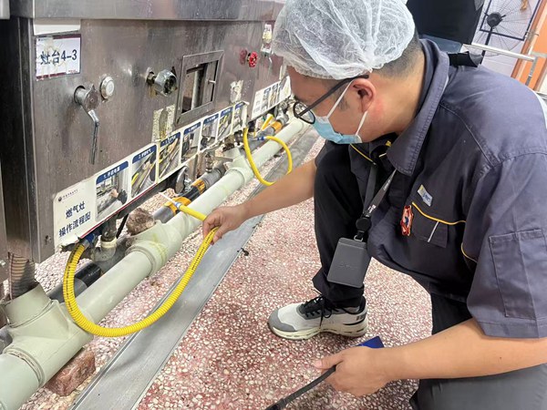 在朝陽中學(xué)南校區(qū)，檢查燃?xì)膺B接軟管。重慶燃?xì)饧瘓F(tuán)供圖