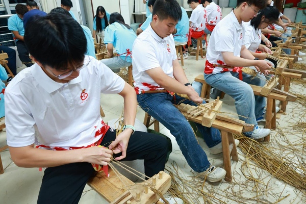 成員們體驗編草鞋。重慶工商職業(yè)學院供圖