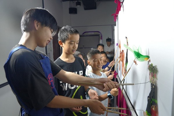 表演老師指導(dǎo)孩子們使用皮影道具。西部航空供圖