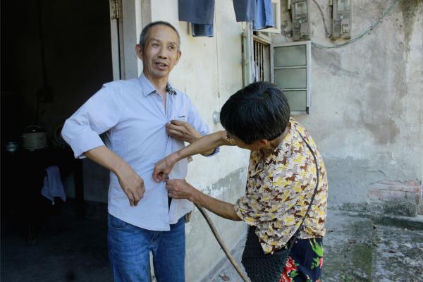 銀齡志愿者為老人整理衣服。鄒冰倩攝