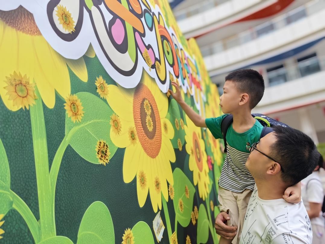 北碚區(qū)兩江春暉小學(xué)一年級(jí)新生在“葵花墻”上貼上小心愿。周輝攝