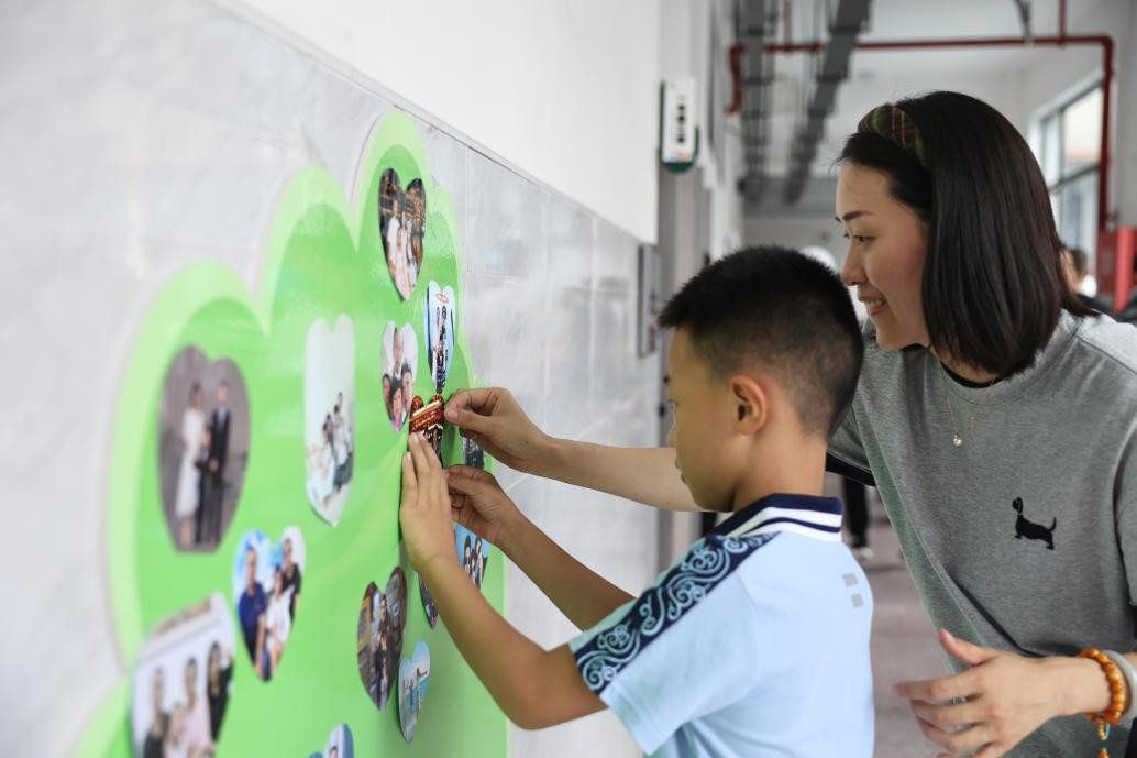 勉仁小學(xué)一年級(jí)新生在成長樹上貼全家福。晏瀅瀅攝