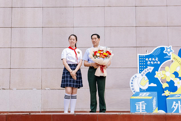 學(xué)生代表向鄧從國(guó)老先生獻(xiàn)花。重慶外國(guó)語(yǔ)學(xué)校供圖