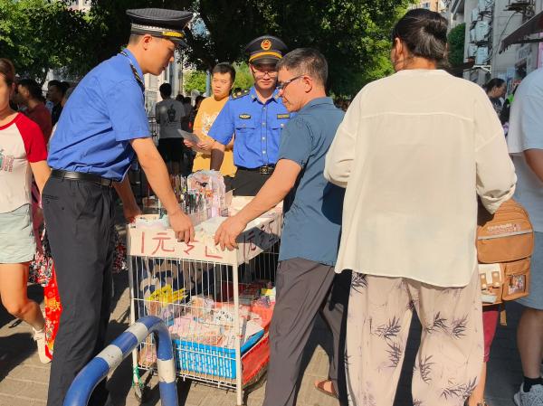 城管隊(duì)員幫助攤販規(guī)范占道經(jīng)營。巴南區(qū)城市管理局供圖