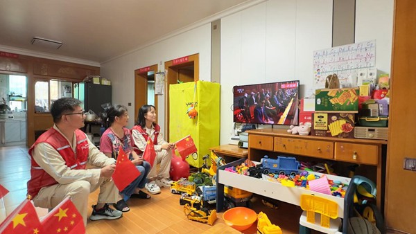 9月3日，重慶市雙橋經(jīng)開區(qū)連二坡社區(qū)，國網(wǎng)永川供電公司雙橋供電中心員工鐘沉霞、黃洋勇等人在開展網(wǎng)格服務(wù)時，與居民周富強收看紀念大會和閱兵儀式直播。宋元攝