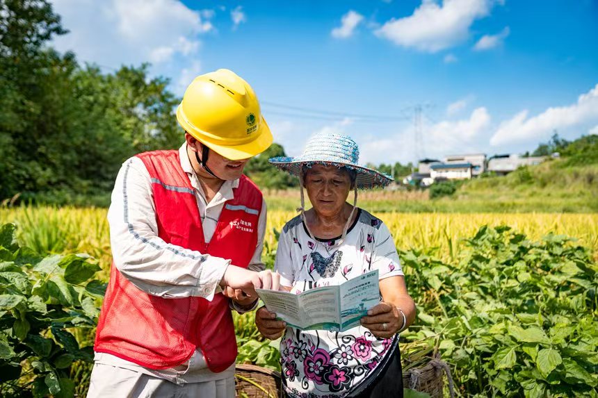 電力人員向村民介紹安全用電知識。國網(wǎng)永川供電公司供圖