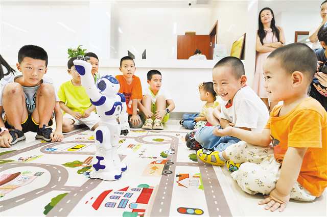 八月二十日，在北碚區(qū)開展的機器人與人工智能科普移動課堂上，孩子們和機器人在互動。特約攝影 秦廷富\視覺重慶