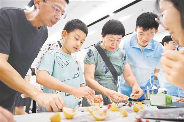 9月13日，2025年重慶市全國(guó)科普月主場(chǎng)活動(dòng)現(xiàn)場(chǎng)，家長(zhǎng)帶著孩子體驗(yàn)水果電池。記者 謝智強(qiáng) 攝/視覺重慶