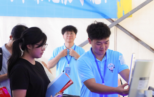 志愿者幫助新生處理報(bào)道流程。重慶城市科技學(xué)院供圖