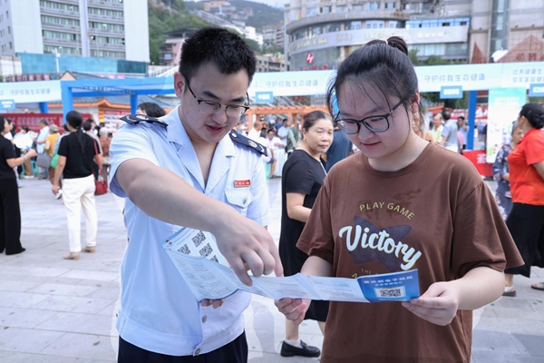 奉節(jié)縣稅務(wù)人員在公平競爭政策宣傳活動(dòng)現(xiàn)場向市民宣傳納稅信用管理相關(guān)政策。孫艷嬌攝