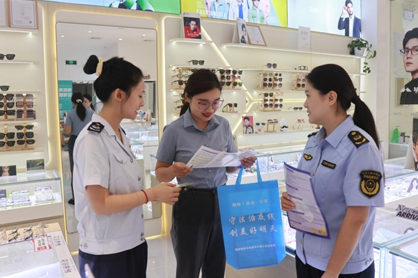 在綦江區(qū)萬達(dá)商圈，稅務(wù)人員走訪商圈內(nèi)的店鋪，宣傳講解稅法條款。任韻西攝