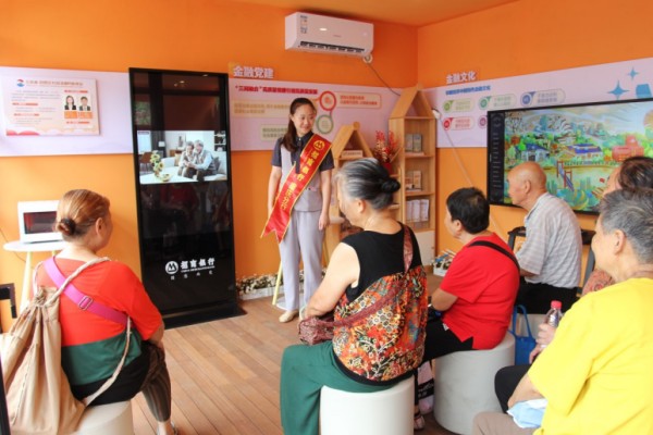 招商銀行重慶分行金融網(wǎng)格員為社區(qū)居民播放金融科普視頻。招商銀行重慶分行供圖