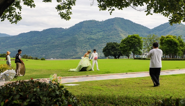 云陽環(huán)湖綠道月光草坪，市民在拍攝婚紗照。譚啟云攝