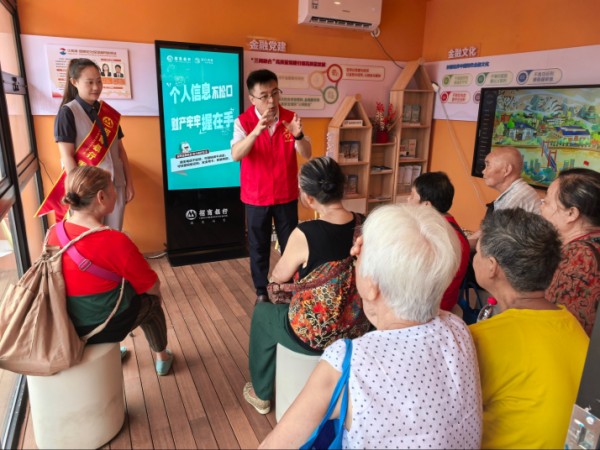 招商銀行重慶分行員工在“紅金渝”忠恕沱社區(qū)金融網(wǎng)格驛站為老年人普及金融知識。招商銀行重慶分行供圖