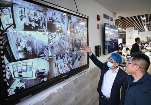 10月29日，位于兩江新區(qū)的兩江育才中學(xué)校食堂，學(xué)校工作人員和膳食委員會(huì)成員通過攝像頭查看售賣廳、庫房、冰箱區(qū)等區(qū)域的實(shí)時(shí)畫面。記者 張錦輝 攝/視覺重慶