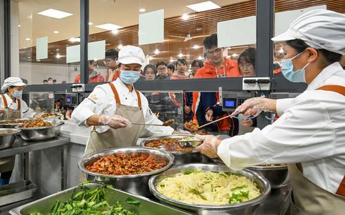 10月29日，位于兩江新區(qū)的兩江育才中學(xué)校，工作人員在食堂售賣廳為學(xué)生們盛飯菜。記者 張錦輝 攝/視覺重慶